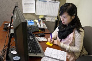 CCHP enrollment counselor Kristen Chow explains Covered California and federal subsidies to a Chinese-language caller. Currently, more than 90 percent of the HMO's members are ethnically Chinese. (Marcus Teply/KQED)
