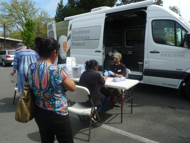 Morgan Smith, a registered nurse with the Redwood Empire Food Bank Diabetes Wellness Project, conducts free diabetes screenings once a month at the Graton Day Labor Center.  The center serves as a conduit between its members -- many of whom are undocumented -- and health organizations around the region. (Lisa Morehouse/KQED)