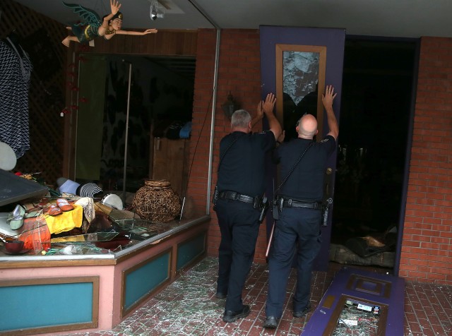 Police officers in Napa prop up a fallen door in front of a damaged building following Sunday's earthquake there. (Justin Sullivan/Getty Images)