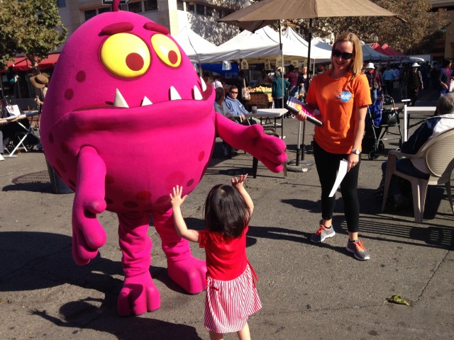The Shoo the Flu mascot helps spread the word on the importance of the flu vaccine at the Old Oakland Farmers Market earlier this month. (Lisa Alifers/KQED)