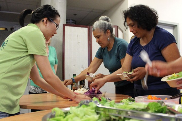 Fresh Approach staffers chop a variety of fruits and vegetables for today’s summer salad. “We tried to choose one of every color,” says Laura deTar, Nutrition Program Manager for Fresh Approach. “We want to expose people to things they may not have had.” (Brittany Patterson, KQED)
