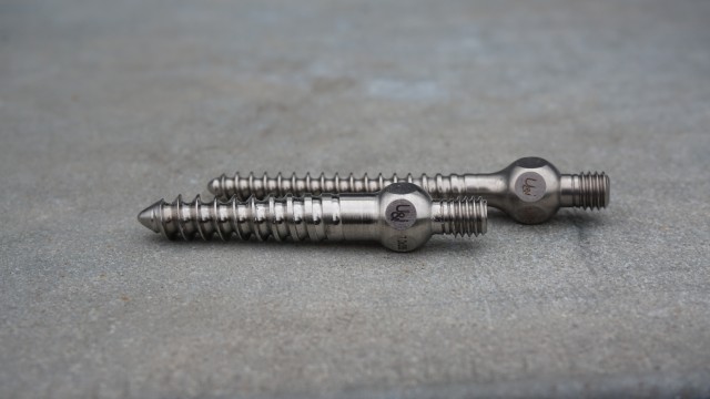 The screw in the foreground is a knockoff of South Korean company U&I Corp.’s product. The real screw, with its italic logo, is in the background. (Michael I. Schiller/CIR)