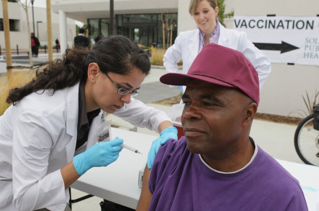 Touro University medical student Shamis Fallah (L) administers a Tdap vaccination in the arm of Phillip Briskell during a 2010 Solano County health fair in  Vallejo.   (Photo by Justin Sullivan/Getty Images)