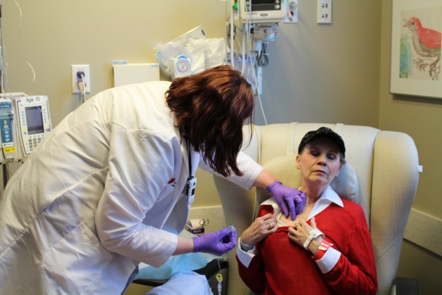 Anne Koller closes her eyes as an oncology nurse attaches a line for chemotherapy to a port in her chest. Koller typically spends 3 to 6 hours getting each treatment. (Sarah Jane Tribble/WCPN)
