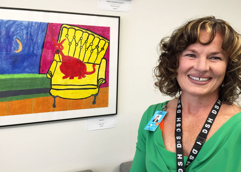 Dolly Matteucci became executive director of Napa State Hospital after Donna Gross's murder. She stands in a conference room decorated with paintings created by psychiatric patients.