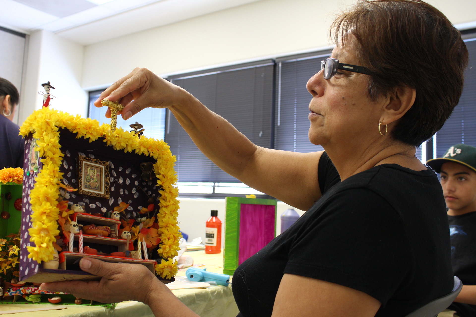 Yolanda Tell shows off a nicho she made for her daughter, as grandson Victor Hugo Perez looks on. Tell’s daugher died in a car accident when Perez was 3 years old. Tell takes care of him and his brother. 