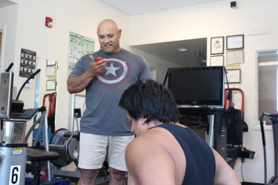 Trainer Johny Gonzales coaches Jorje Mendez through a set of exercises at Lake County Tribal Health Consortium. Increasing physical activity is a key goal of the clinic's diabetes prevention program.