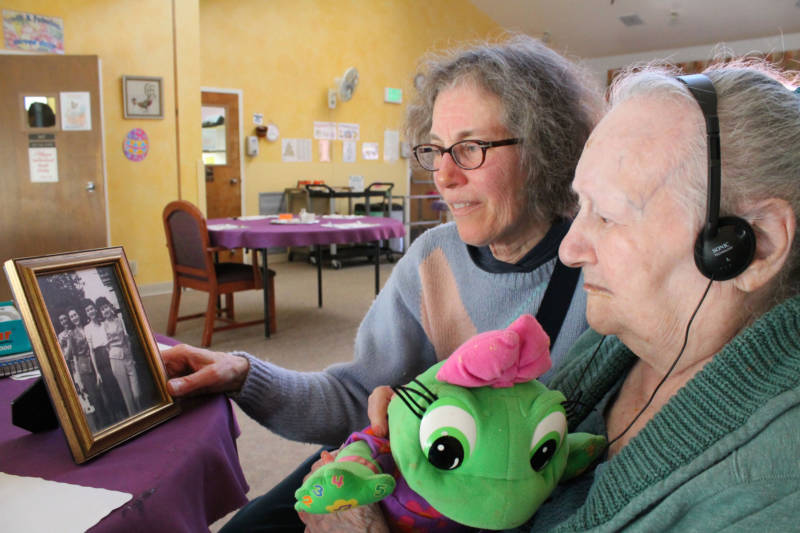 Diane Schoenfeld (left) and her aunt, Lillie Manger, look at old family photos in the dining room of Berkeley's Chaparral House, the nursing home Manger lives in.