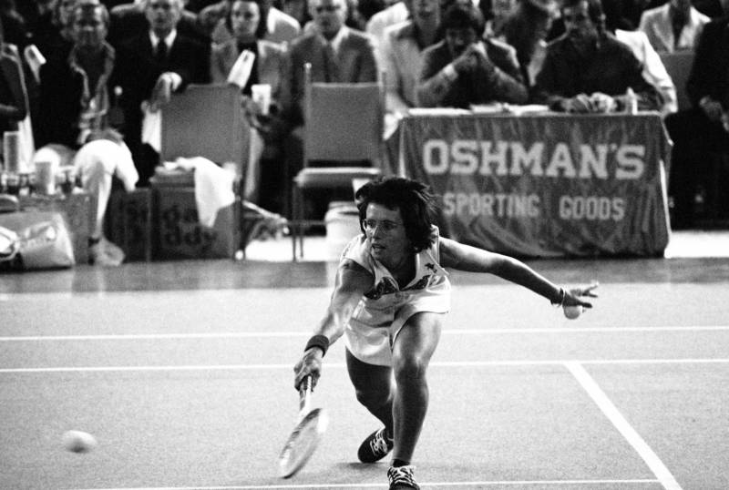 Billie Jean King bends down low to send the ball back over the net during the match with Bobby Riggs in the Astrodome in Houston, Texas on Sept. 20, 1973. ("American Masters: Billie Jean King")