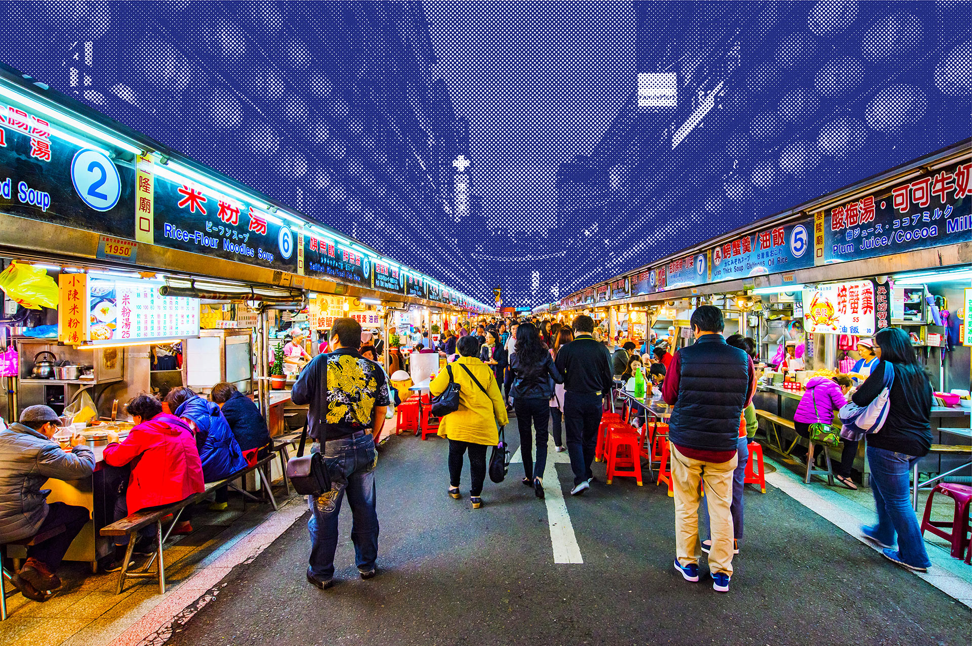 A crowded night market in Taiwan lined with brightly lit food stalls.