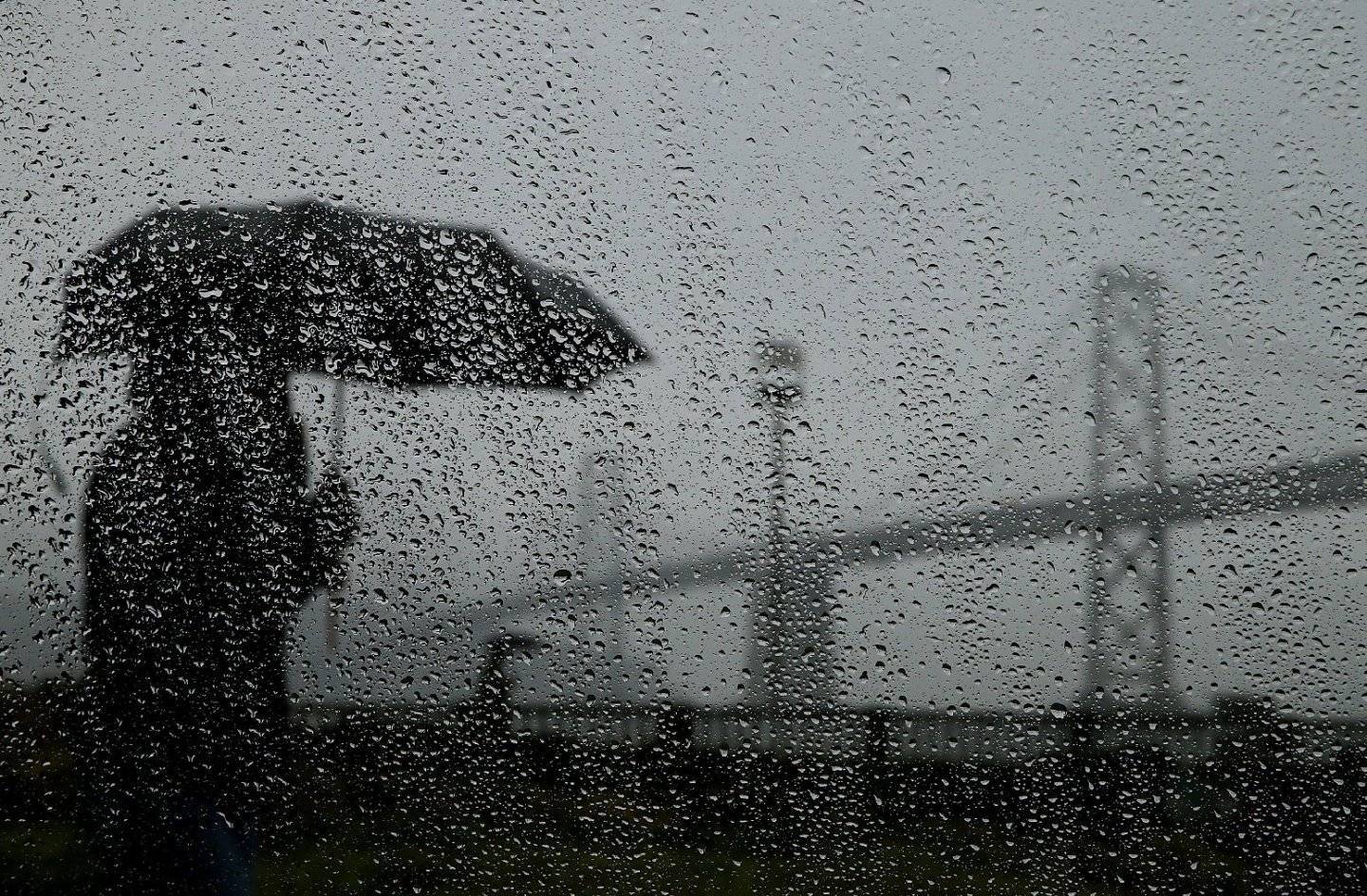 Pedestrian in the rain along San Francisco's Embarcadero. (Justin Sullivan/Getty Images