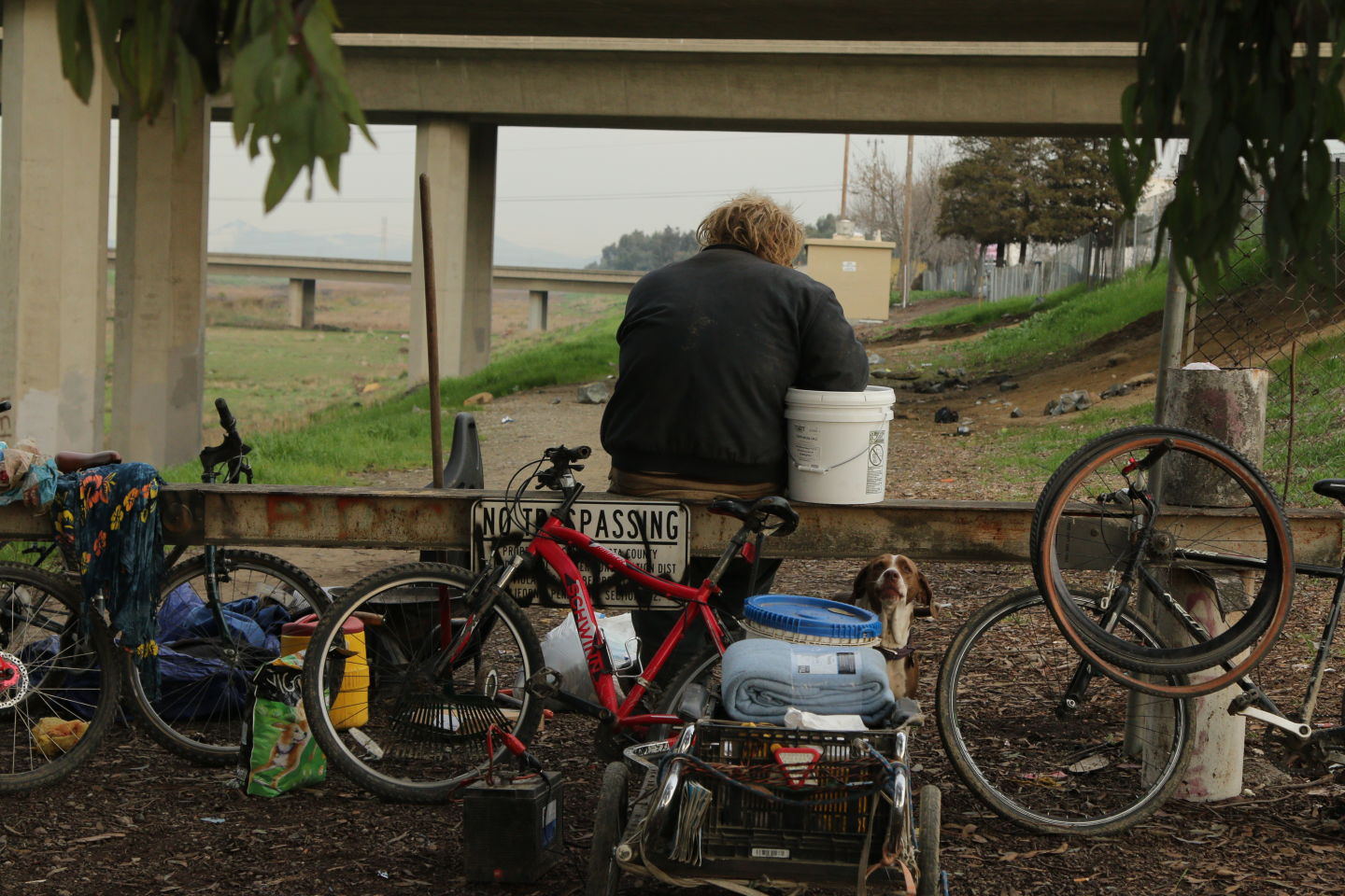 A homeless man sits at his encampment in Contra Costa County, where volunteers warned of a rainstorm that could flood the canal under the overpass where he was situated.  Ericka Cruz Guevarra/KQED