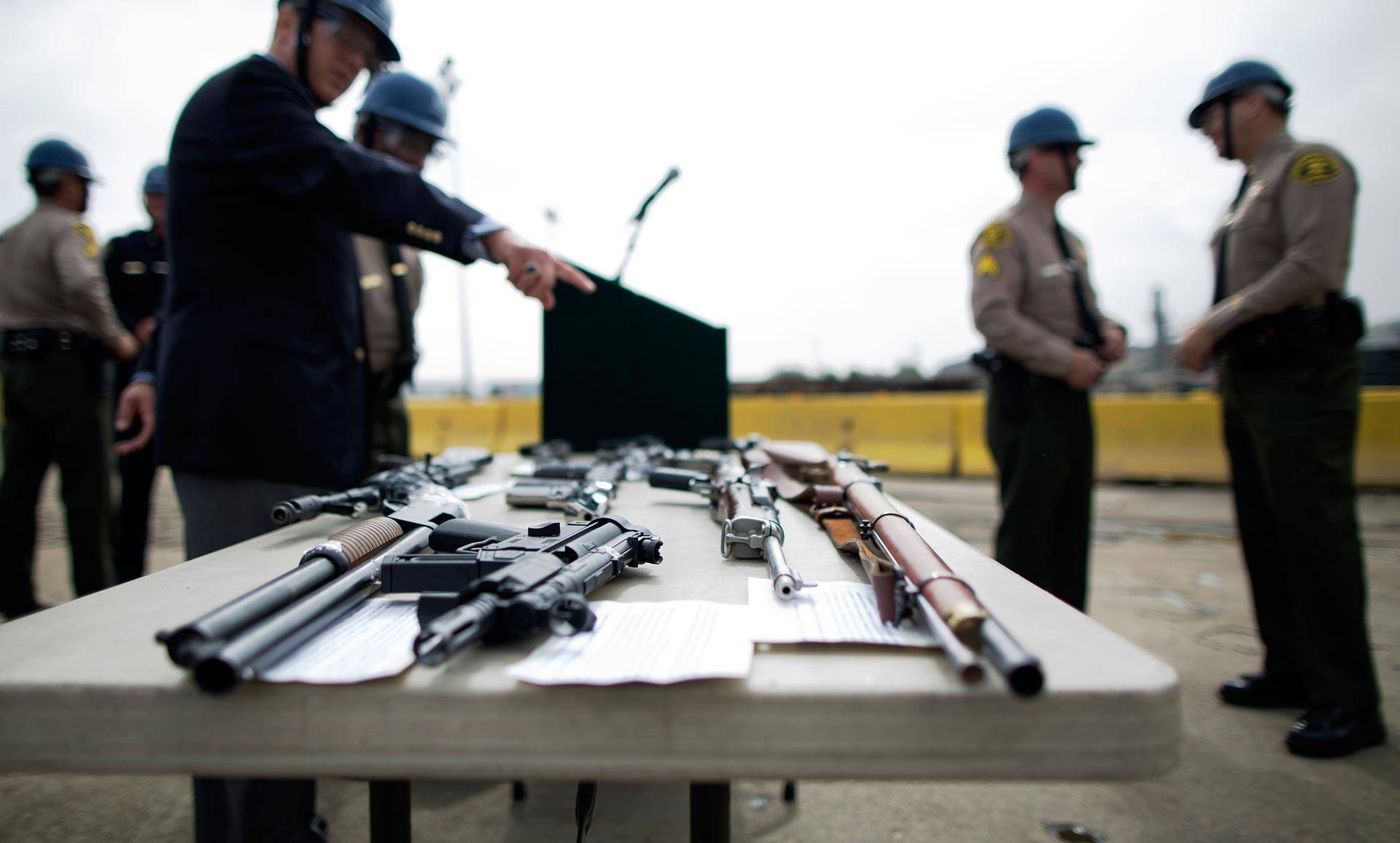 Officials look at guns confiscated in various law enforcement operations at a Los Angeles County Sheriff's Department annual gun melt. David McNew/Getty Images