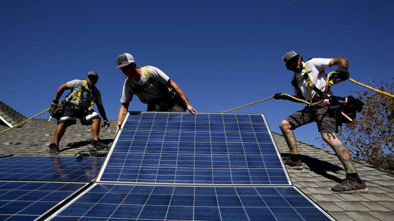 Workers install solar panels on the roof of a home in Camarillo in 2013. San Francisco has recently decided to start requiring rooftop solar systems — electrical or heating — on new construction up to 10 stories tall.