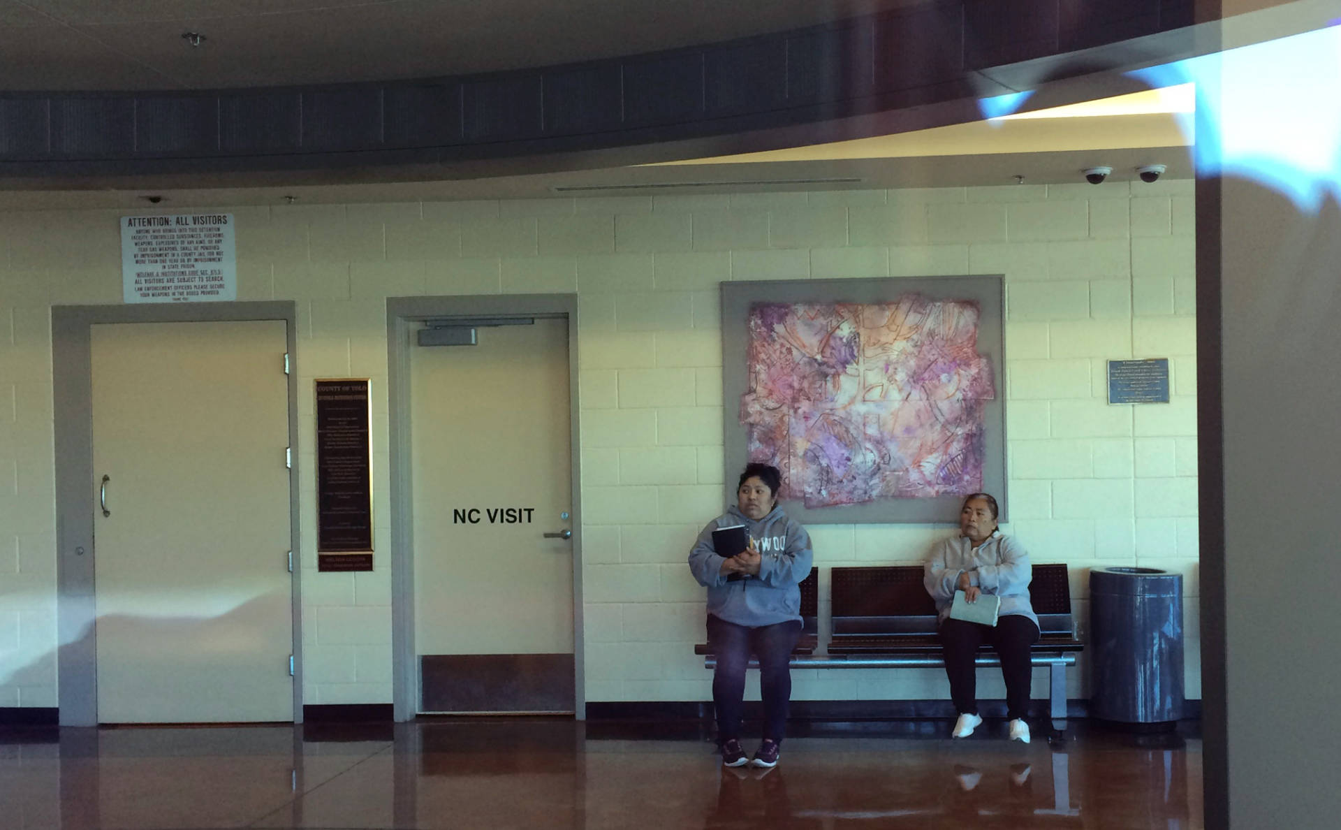 Pablo Aguilar's mother, Evelyn, and grandmother, Albertina, wait in the lobby of the Yolo County Juvenile Detention Facility to visit Pablo, who has been locked in confinement by the Office of Refugee Resettlement since June of 2014. Tyche Hendricks/KQED