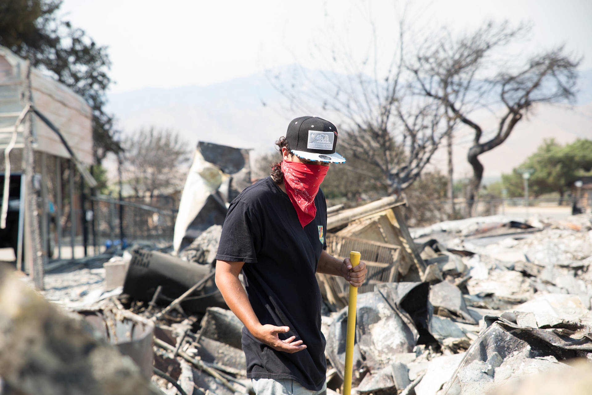 Aquivo Sun, 26, searches the rubble of his South Lake home June 26 for the remains of his missing dog. Sun and his girlfriend, Brittany Thompson, 24, already found one of their dogs among the debris days earlier. They lived off Goat Ranch Road, a neighborhood the Erskine Fire turned to ashes.  Brian Rinker/KQED