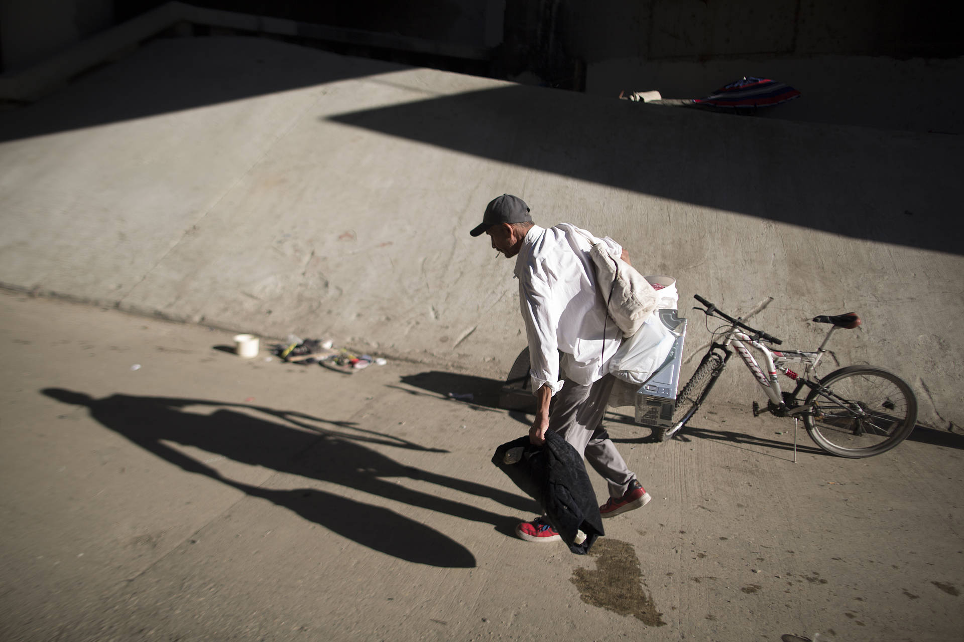 Fernando Lopez carries possessions from the Los Angeles River on Nov. 20, 2015, in Los Angeles, California. Many of the estimated 26,000 homeless in L.A. live in riverbeds and storm drains that could quickly turn deadly during powerful storms.  David McNew/Getty Images