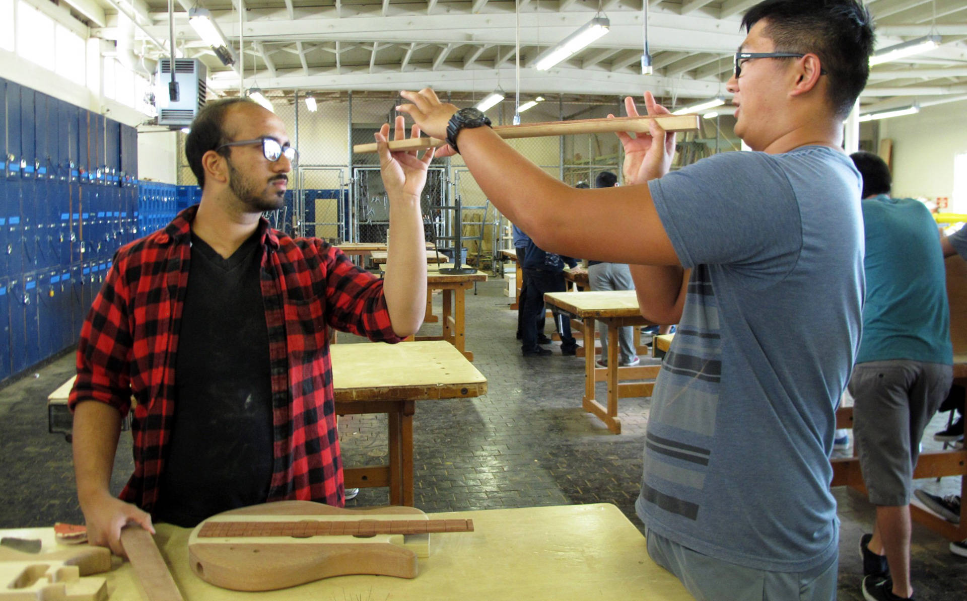 Senior Timothy Lee (R) checks out the curve on his fretboard with help from classmate Farhan Saleh. The two are taking wood shop and physics at Camarillo High School as part of the STEM Guitar Project. Susan Valot/KCRW