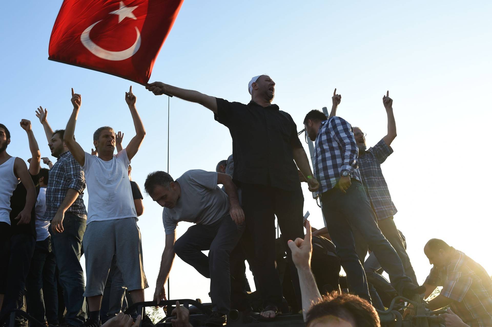 People react after they take over military position on the Bosphorus bridge in Istanbul on July 16, 2016. At least 60 people have been killed and 336 detained in a night of violence across Turkey sparked when elements in the military staged an attempted coup, a senior Turkish official said. The majority of those killed were civilians and most of those detained are soldiers, said the official, without giving further details.  BULENT KILIC/AFP/Getty Images