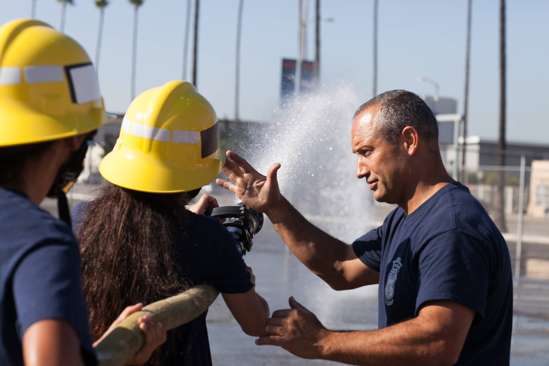LAFD Capt. Eddie Marez instructs cadets at Banning High on how to operate a fire hose. Roxanne Turpen/NPR