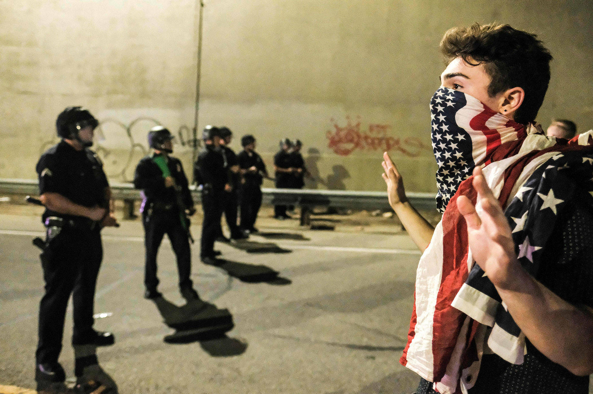 A protester (R) confronts police as protesters shut down the 101 Freeway following a rally one day after Donald Trump's presidential election victory in Los Angeles, late on November 9, 2016.  RINGO CHIU/AFP/Getty Images