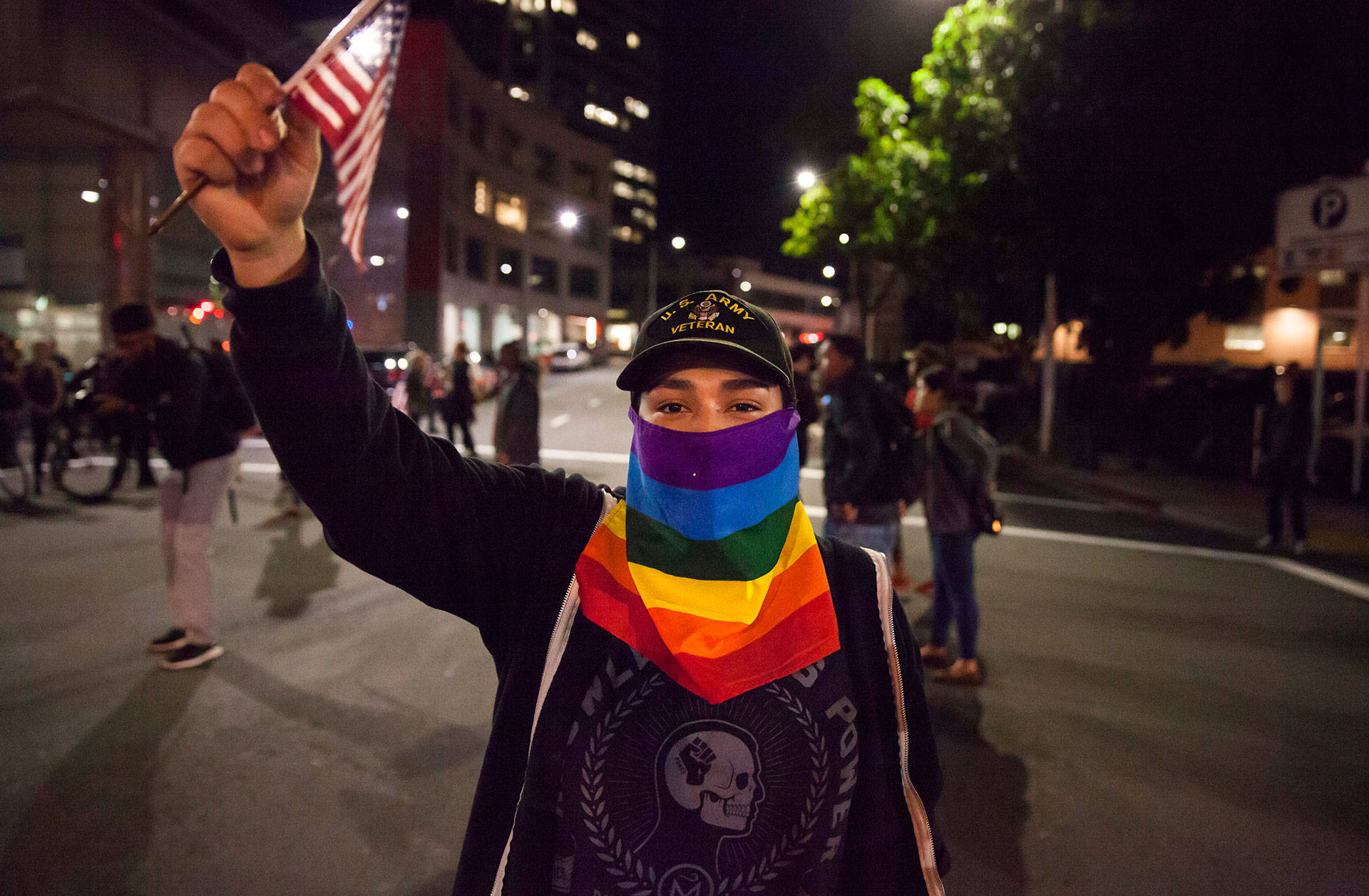 An anti-Donald Trump protester holds an American flag during a protest in Oakland last week.
 Brittany Hosea-Small/KQED
