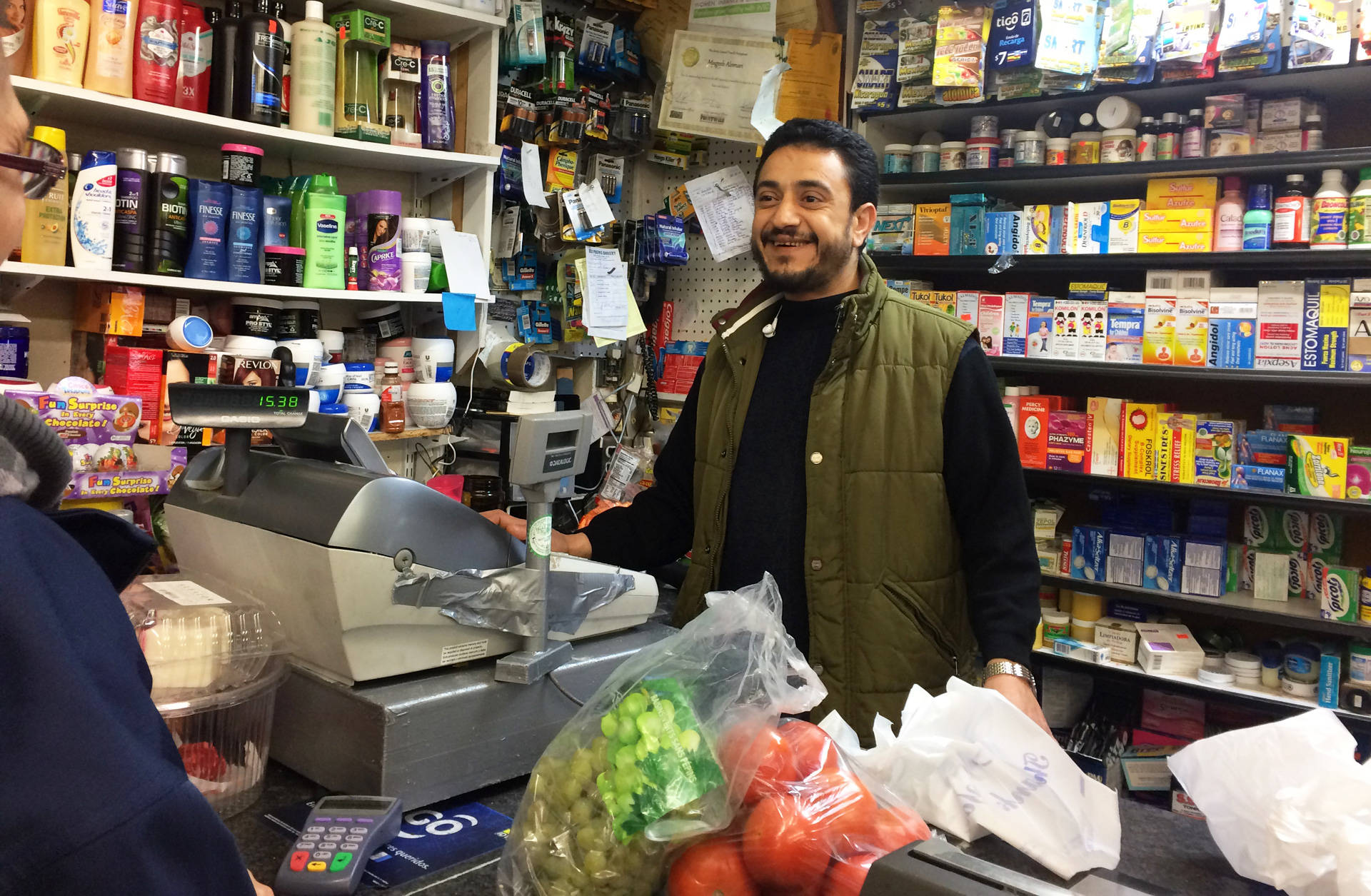 Mogeeb Alomri chats with customers at his grocery store in Oakland. Alomri believes President Trump's immigration orders could hurt his business and the likelihood his Yemeni wife and children can emigrate to the U.S.  Farida Jhabvala Romero/KQED