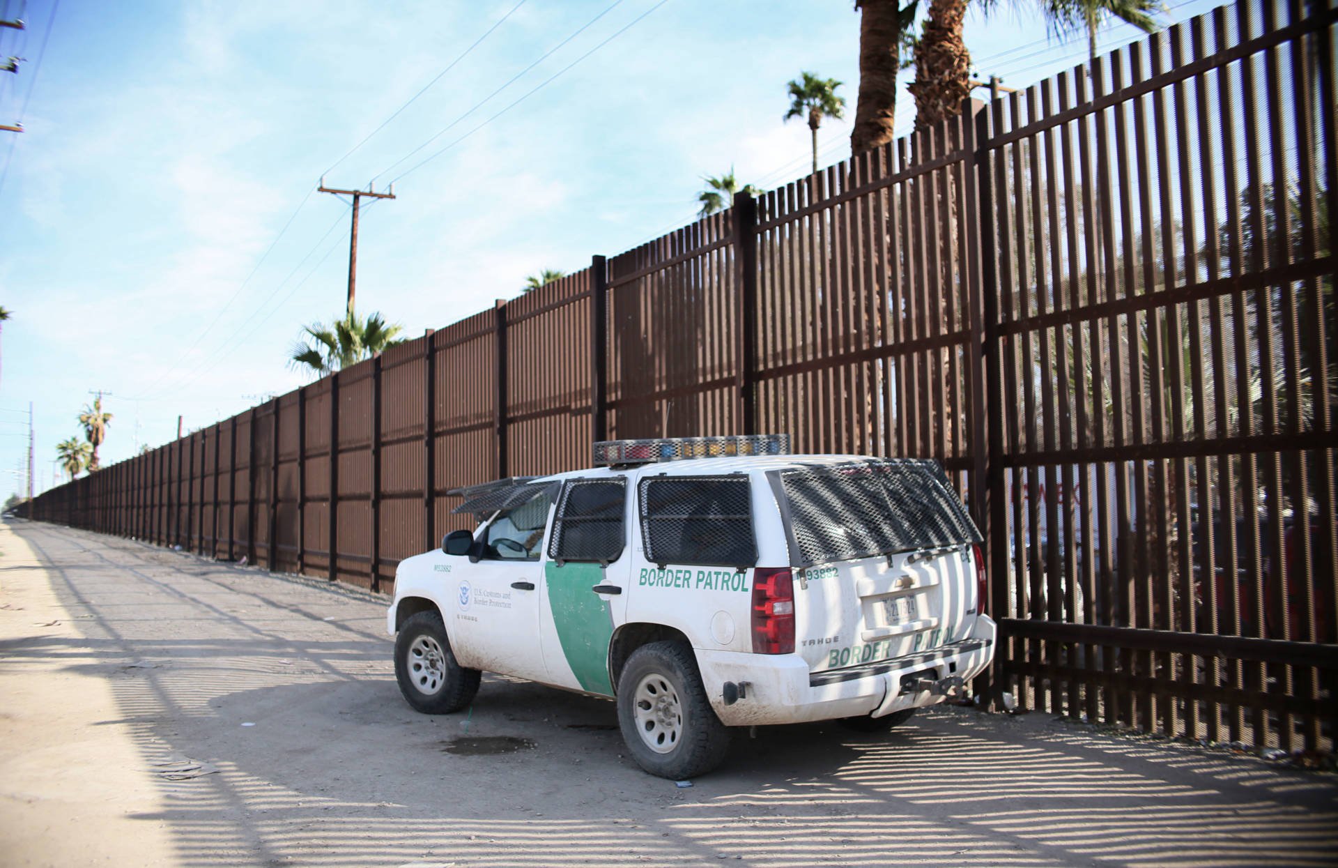A Border Patrol agent looks over the U.S.-Mexico border wall in Calexico on Jan. 31. Apprehensions at the southern border fell dramatically: from more than 40,000 per month late last year to 18,754 in February, and just 12,193 in March. Sandy Huffaker/AFP/Getty Images