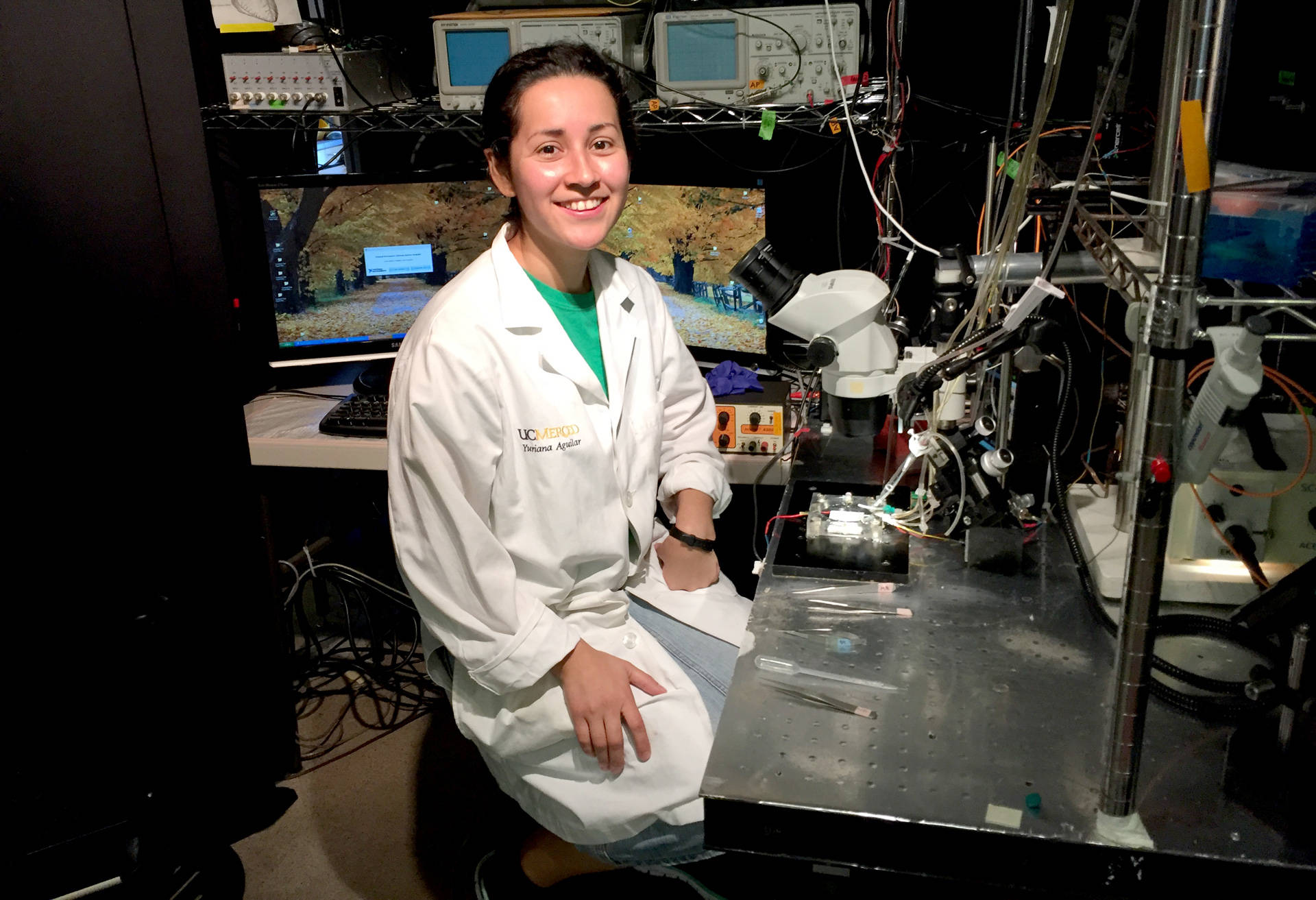 Yuriana Aguilar sits at her microscope in a biomedical lab at UC Merced that studies sudden cardiac death. Sasha Khokha/KQED