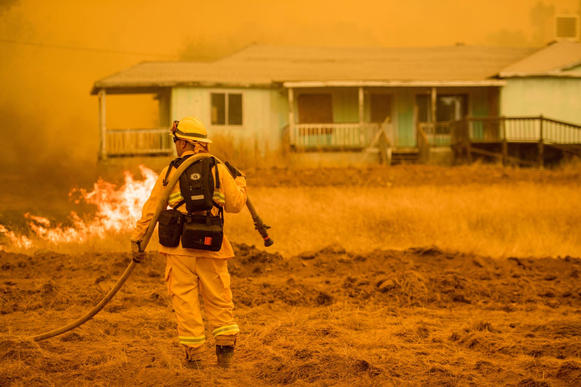 A firefighter works to protect a home in Mariposa, California on July 19, 2017. Josh Edelson/AFP/Getty Images