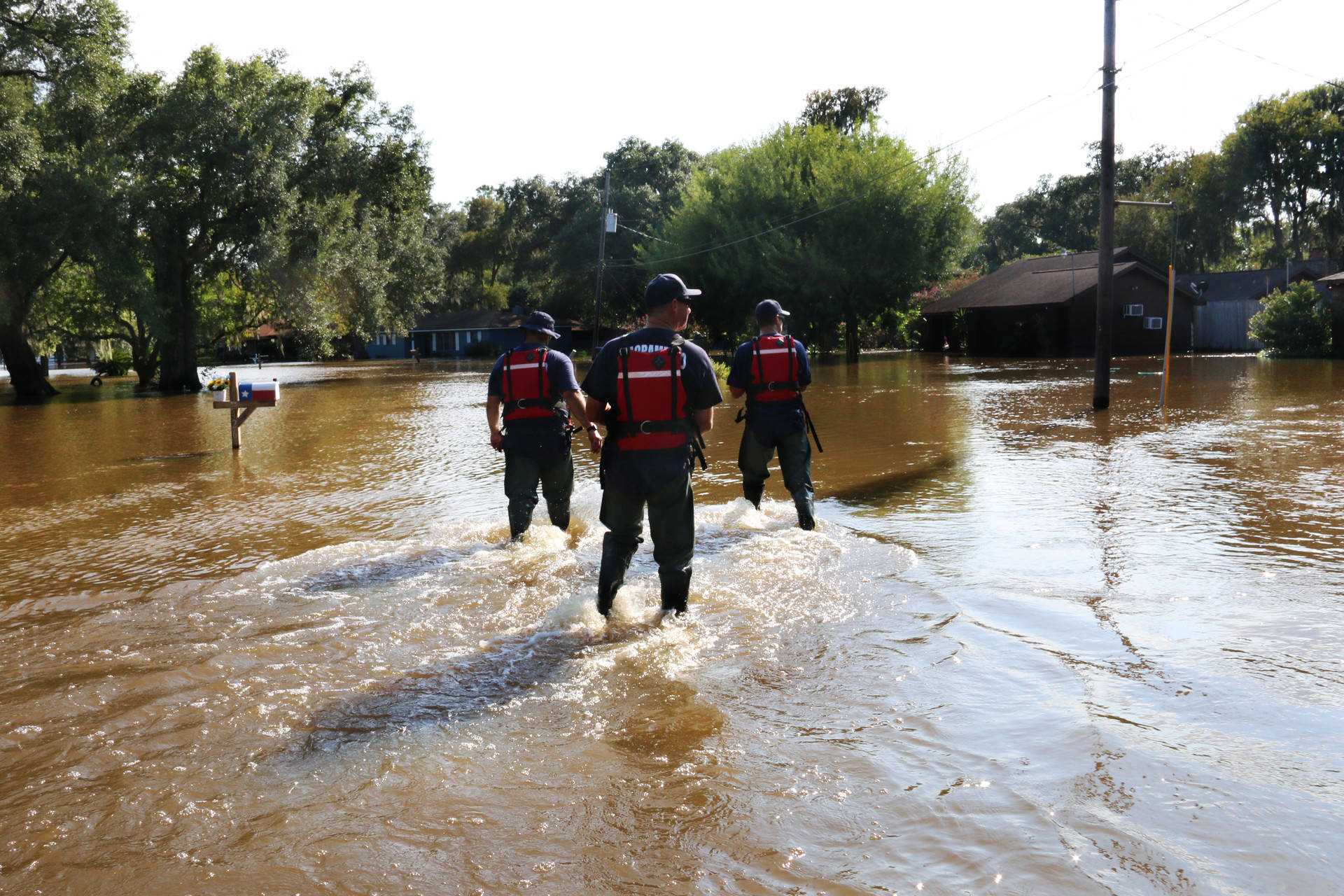 (From Left) Scott Lewis, Mike Wolfe and Dave Lauchner, members of Urban Search and Rescue California Task Force 7 and the Sacramento Fire Department, walk through Richwood, Texas, on Sept. 3, 2017. Richwood is one of many rural communities that continue to see major flooding over a week after Hurricane Harvey hit Texas. Alex Emslie/KQED