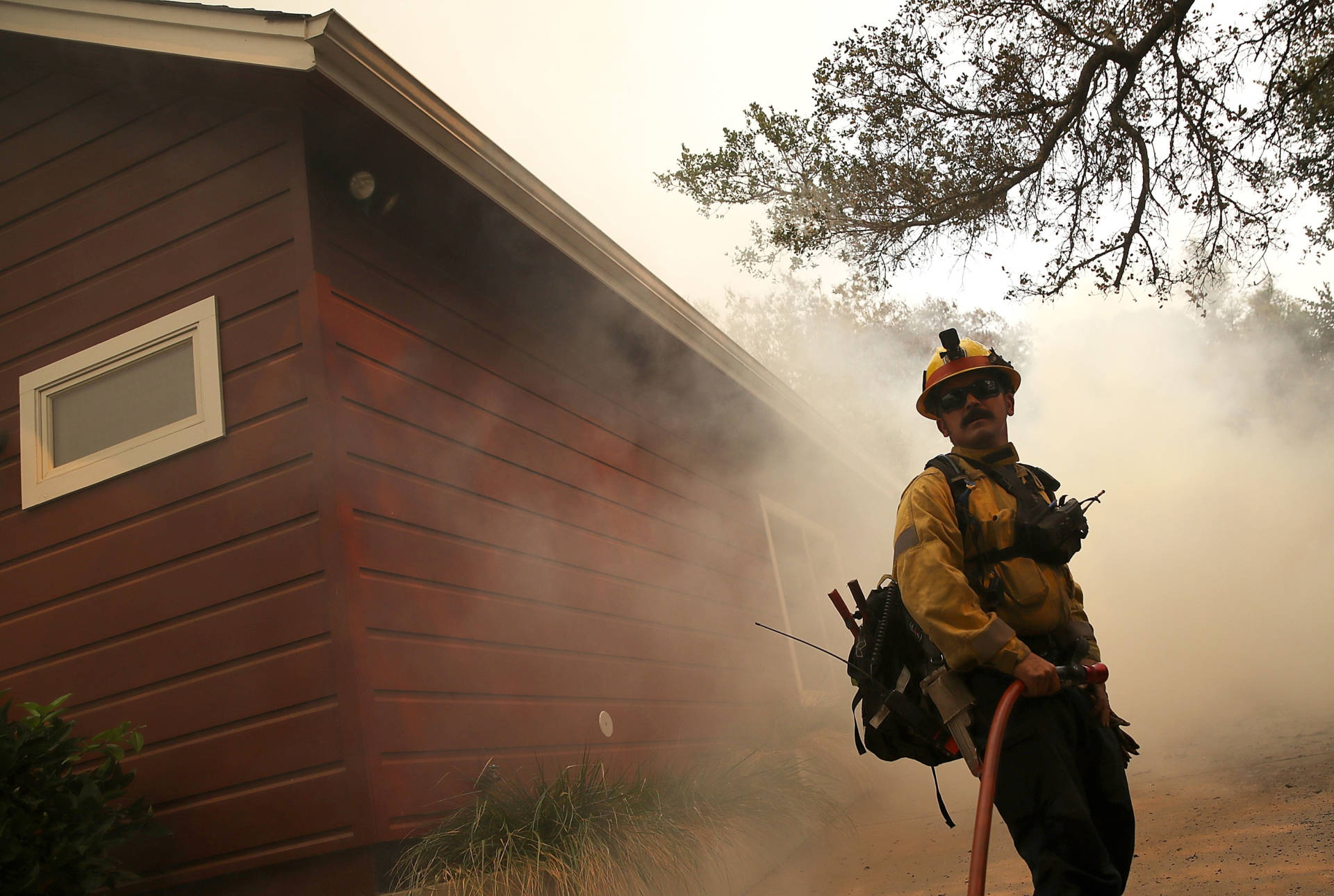 A Los Angeles County firefighter monitors approaching flames near a building as an out-of-control wildfire moves through the area on Oct. 9, 2017, in Yountville, north of Napa. Justin Sullivan/Getty Images