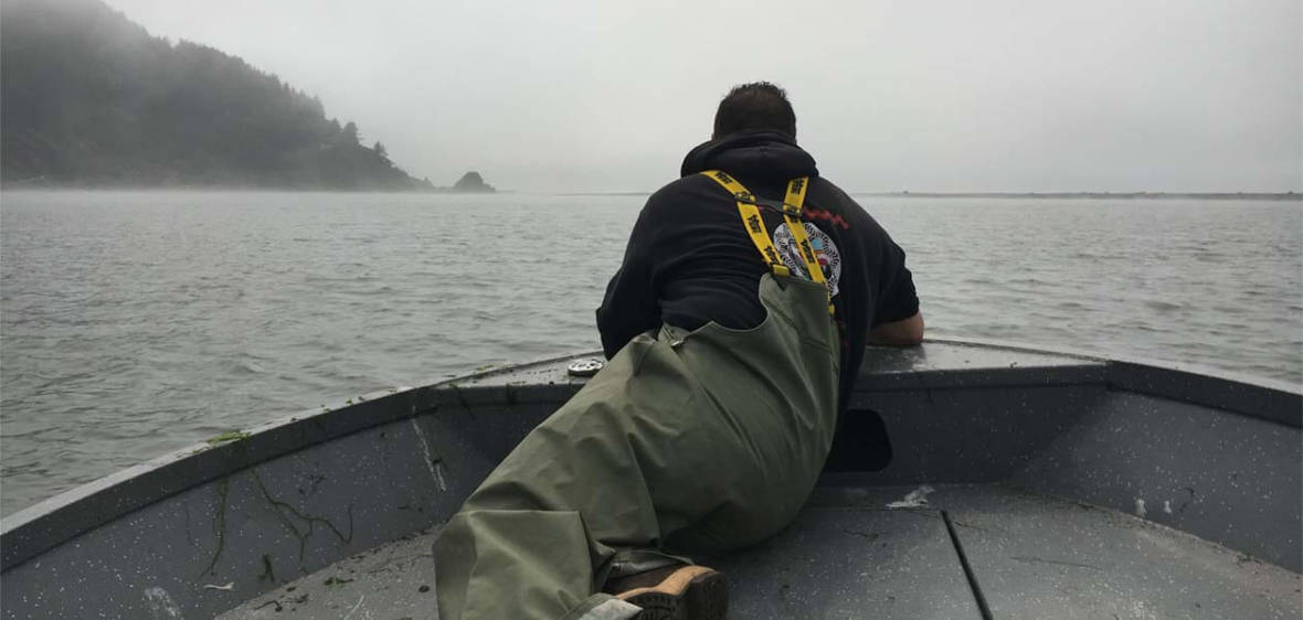 Jerome Nick Jr. peers over the bow while checking nets near the mouth of the Klamath River in California's far north.  Lisa Morehouse/KQED