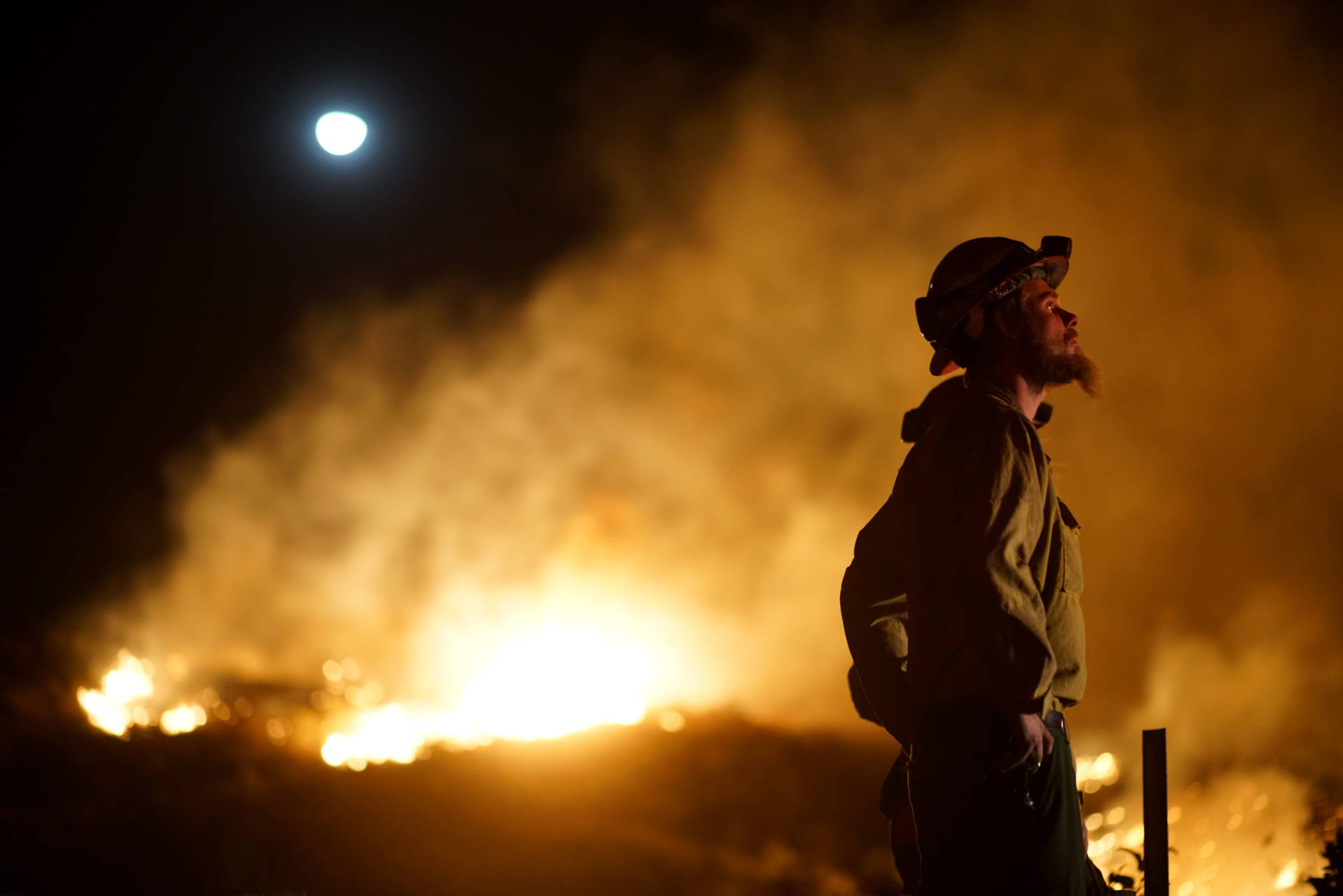 A firefighter watches the fire line at the Lilac fire in Bonsall, California on Dec. 7, 2017. Local emergency officials warned of powerful winds on Dec. 7 that will feed wildfires raging in Los Angeles, threatening multi-million dollar mansions with blazes that have already forced more than 200,000 people to flee. Sandy Huffaker/AFP/Getty Images