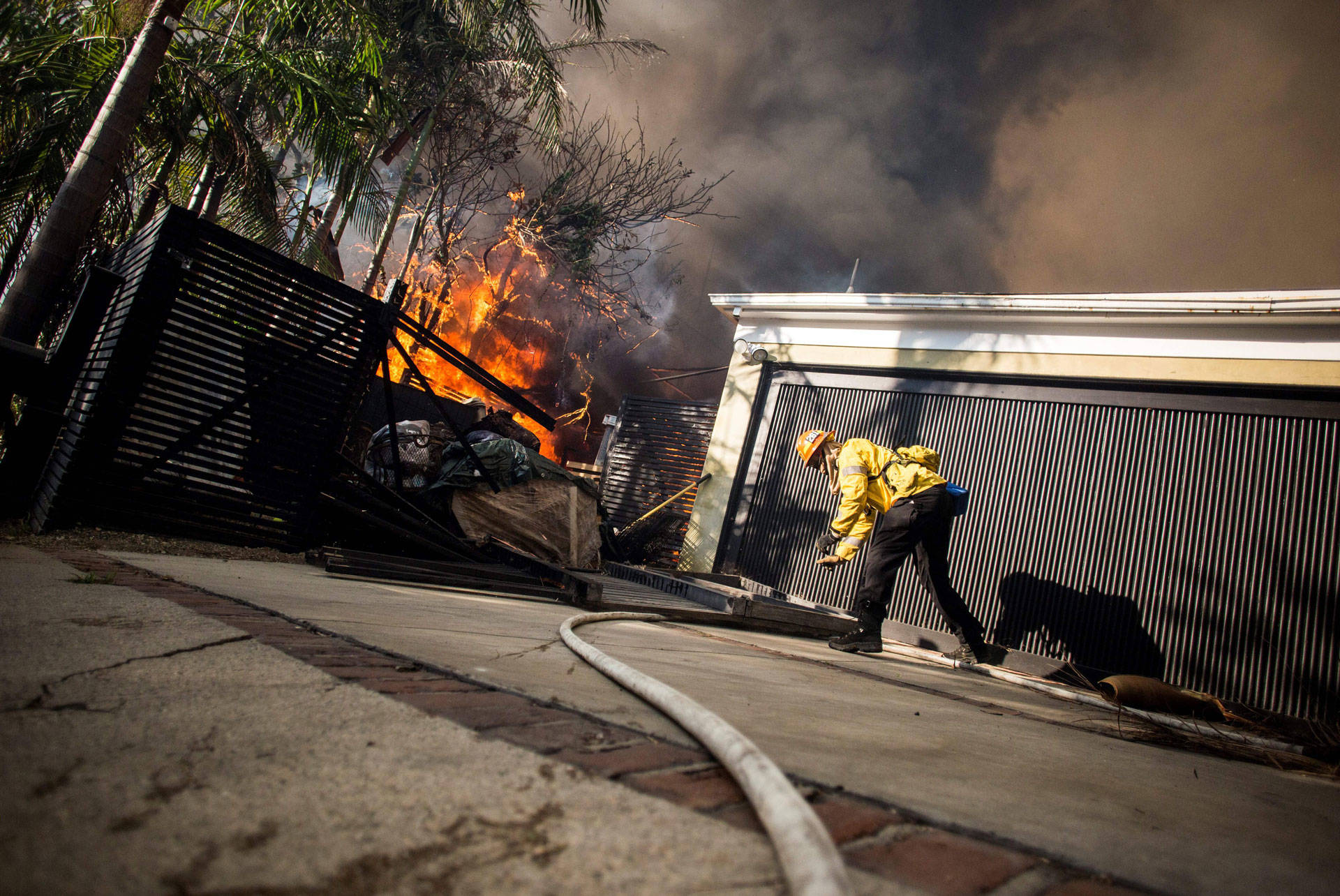 Firefighters work to save burning houses along Linda Flora Drive during the Skirball Fire in Los Angeles on Dec. 6, 2017.  KYLE GRILLOT/AFP/Getty Images