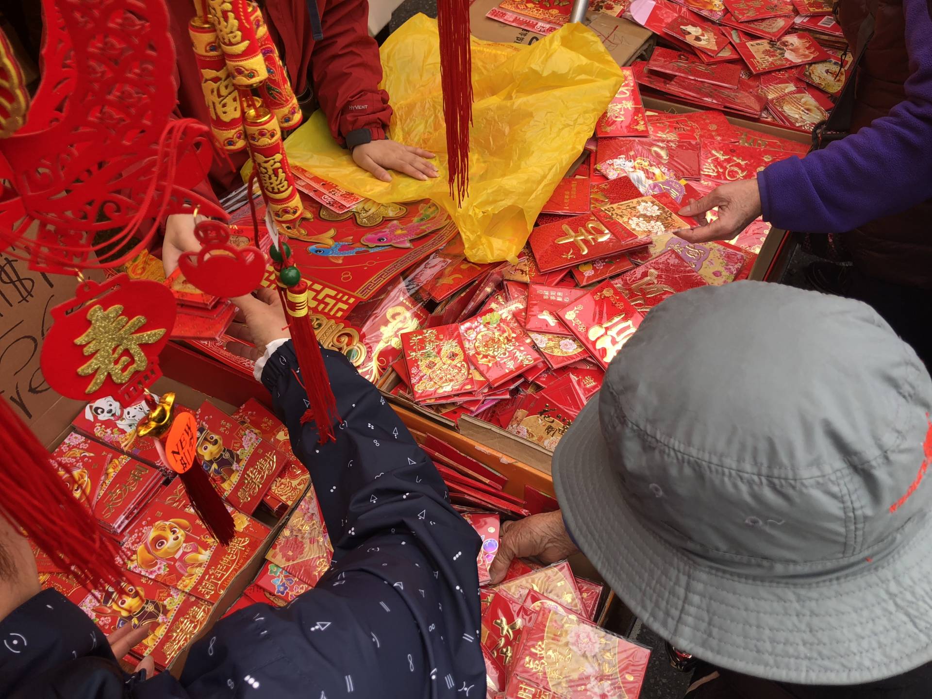 Elderly ladies pick over red envelopes at the Chinese New Year Flower Market Fair. The market is held before Chinese New Year proper in order for people to buy flowers, fruit, candy and plants before the new lunar year. Alyssa Jeong Perry/KQED