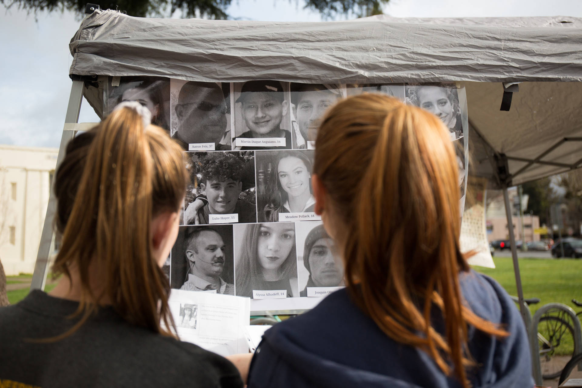 Students at Oakland Technical High School look at a billboard with photos of the 17 victims of the Parkland, Florida, mass shooting during a walkout to protest gun violence on March 14, 2018. Samantha Shanahan/KQED
