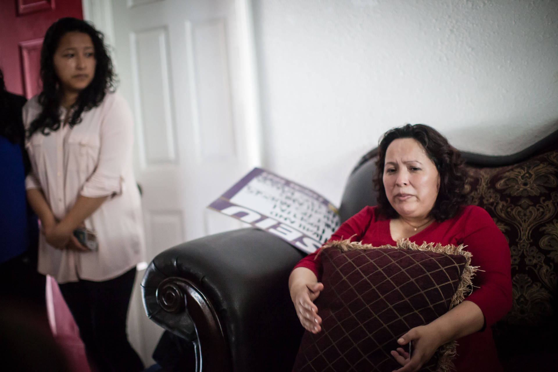 Maria Mendoza-Sanchez sits on a couch in her Oakland home on Aug. 16, 2017, hours before she, her husband and son leave Oakland for Mexico City. Her daughter, Melin Sanchez, 21, cries as she watches her mother with concern. Deborah Svoboda/KQED