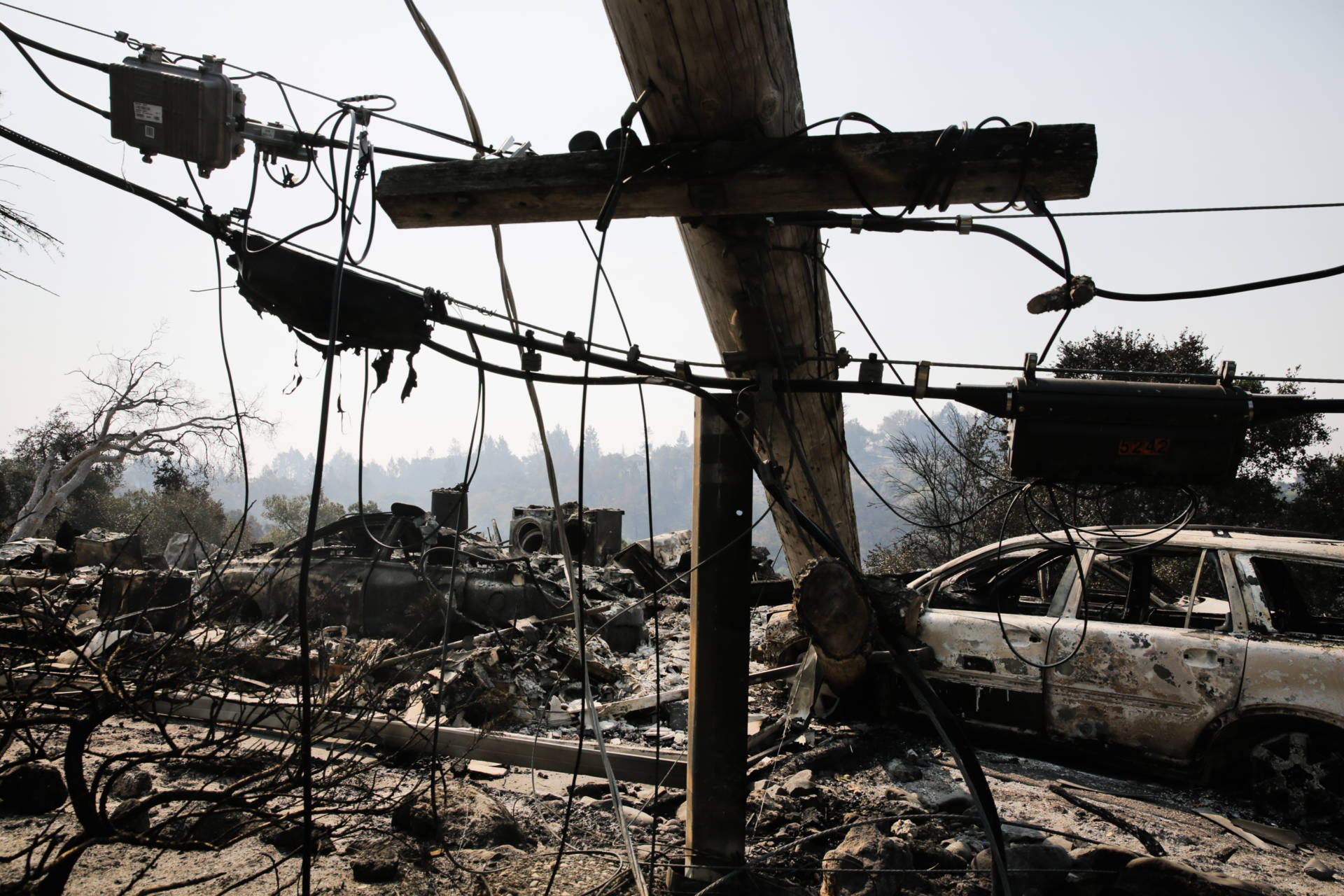  A downed power line and the remains of a home and a car are seen in Santa Rosa's Larkfield-Wikiup neighborhood after last October's Tubbs Fire. Elijah Novelage/Getty Images