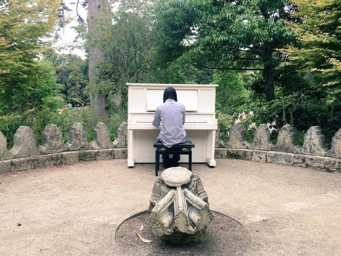 A guest plays a piano in the rhododendron garden. Michelle Wiley/KQED