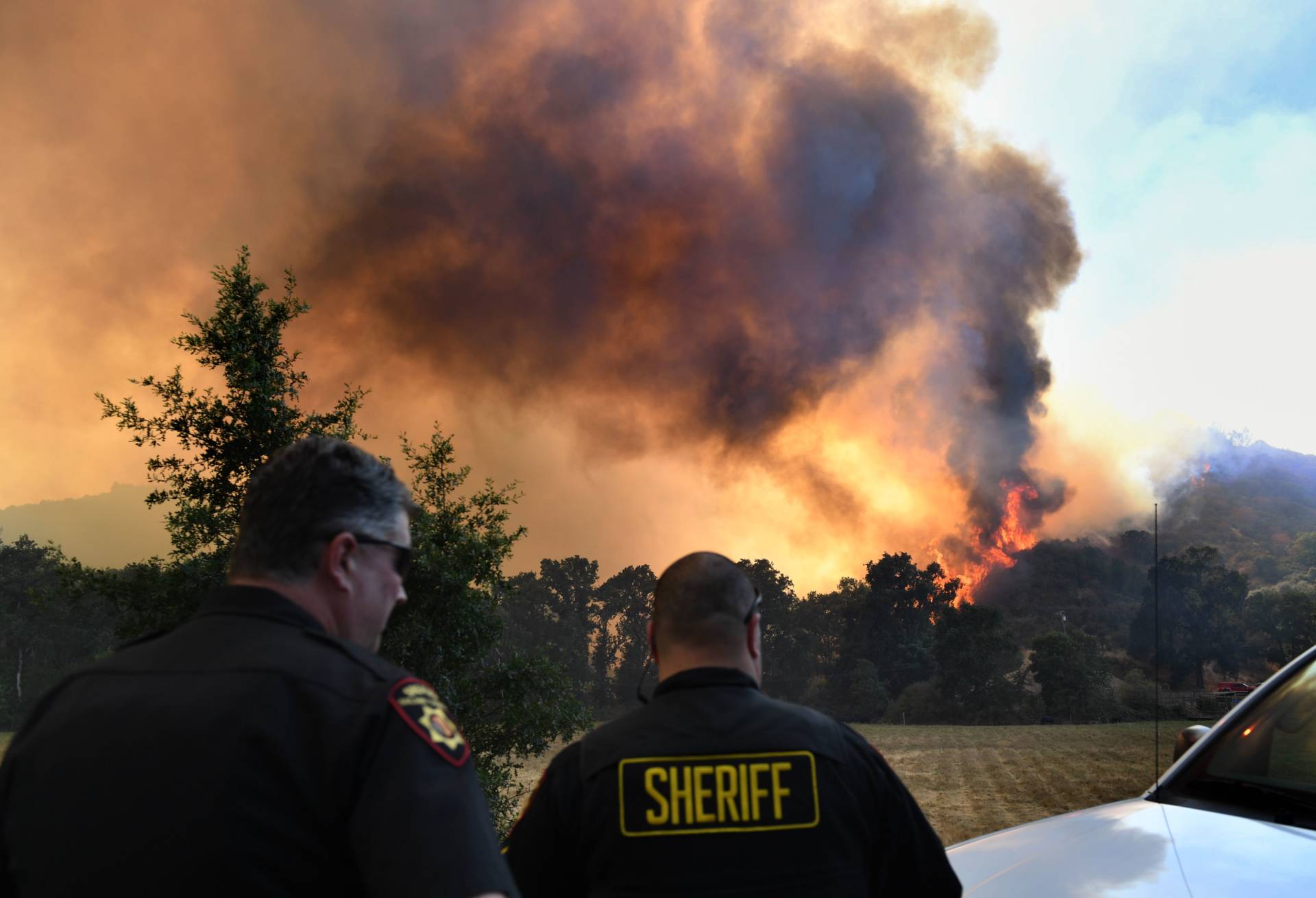The town Sheriff watches the wind swept flames from the River fire as it again threatens the town of Lakeport on August 3, 2018.  MARK RALSTON/AFP/Getty Images