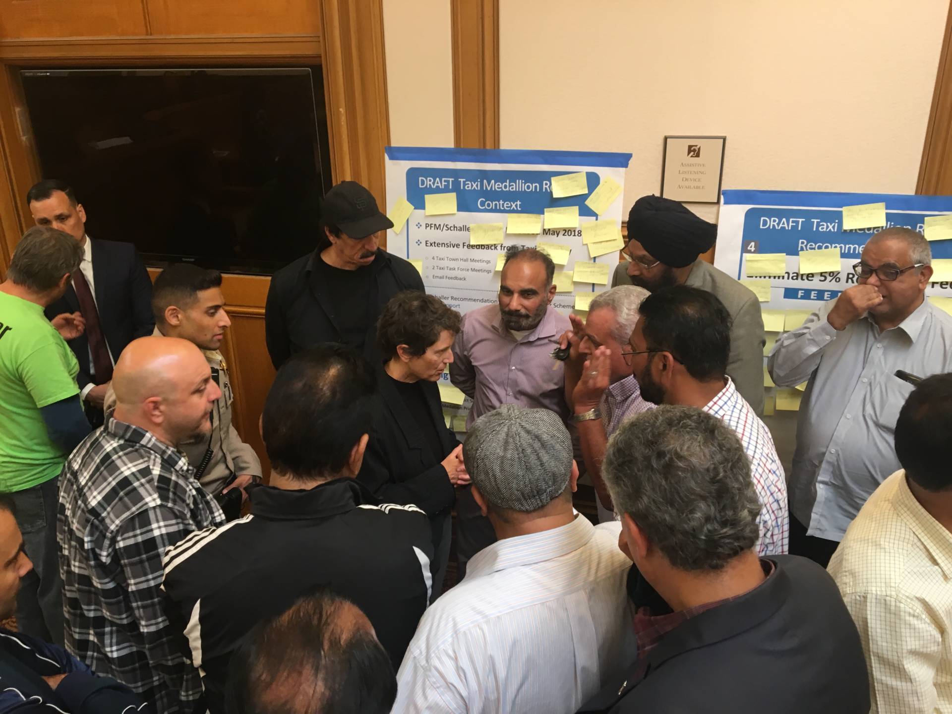 At a recent SFMTA meeting, taxi drivers surrounded Kate Toran, who heads the city's taxi program. Sam Harnett/KQED