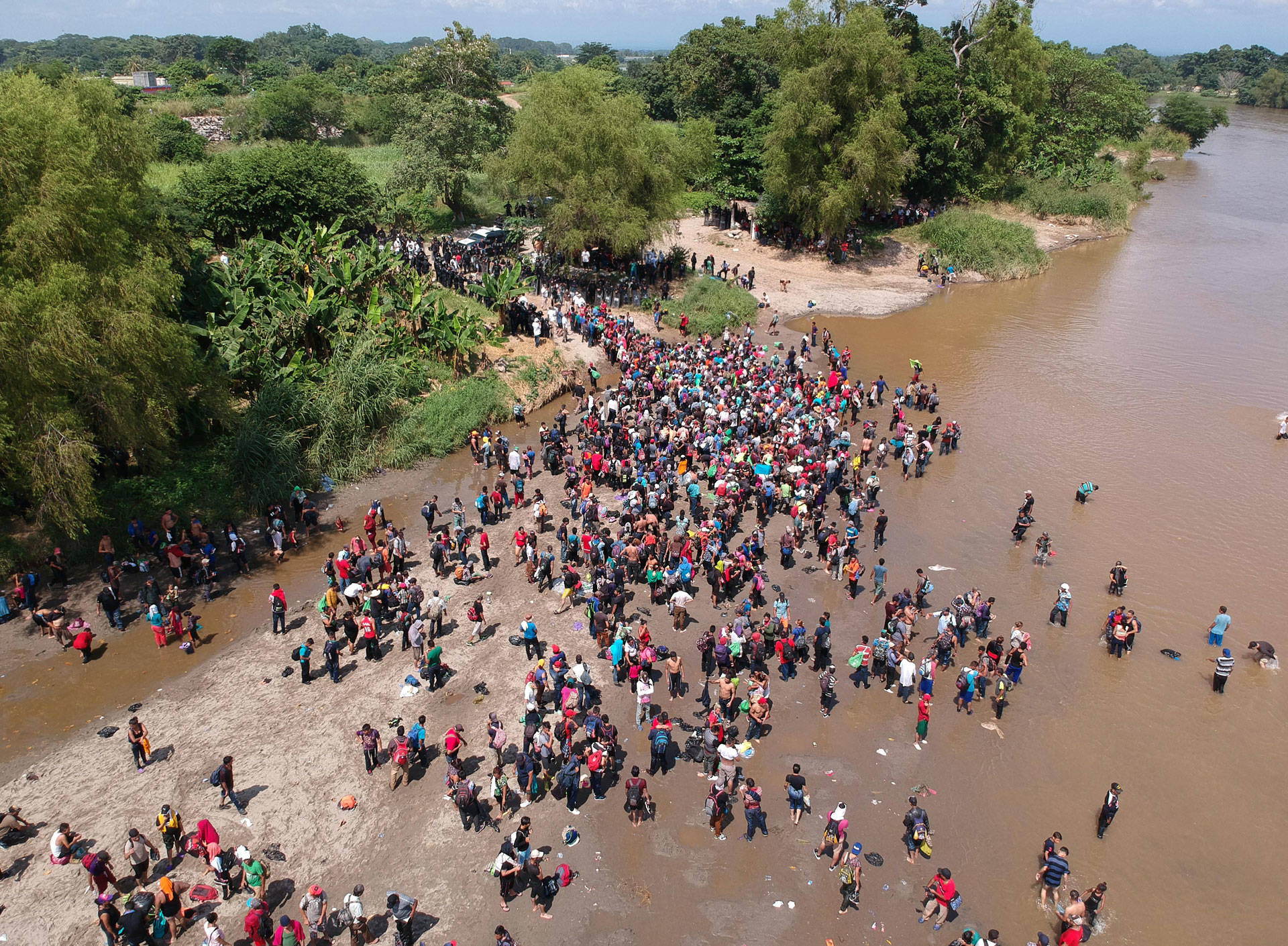 Migrants reach Mexico after crossing the Suchiate River from Tecun Uman in Guatemala to Ciudad Hidalgo in Mexico on Oct. 29, 2018, a day after a security fence on the international bridge was reinforced to prevent them from passing through. CARLOS ALONZO/AFP/Getty Images