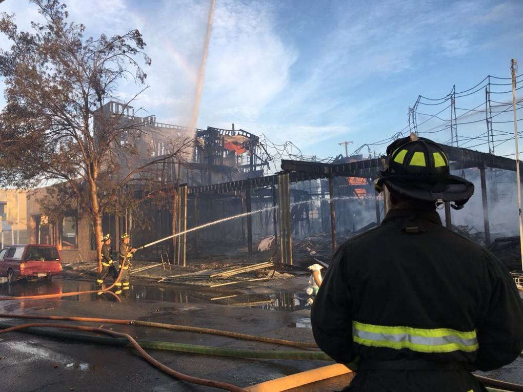 Oakland firefighters on scene at Tuesday morning's blaze at an under-construction town home development at West Grand Avenue and Myrtle Street. <a href="https://twitter.com/oaklandpoliceca" target="_blank">Oakland Police Department</a> via Twitter