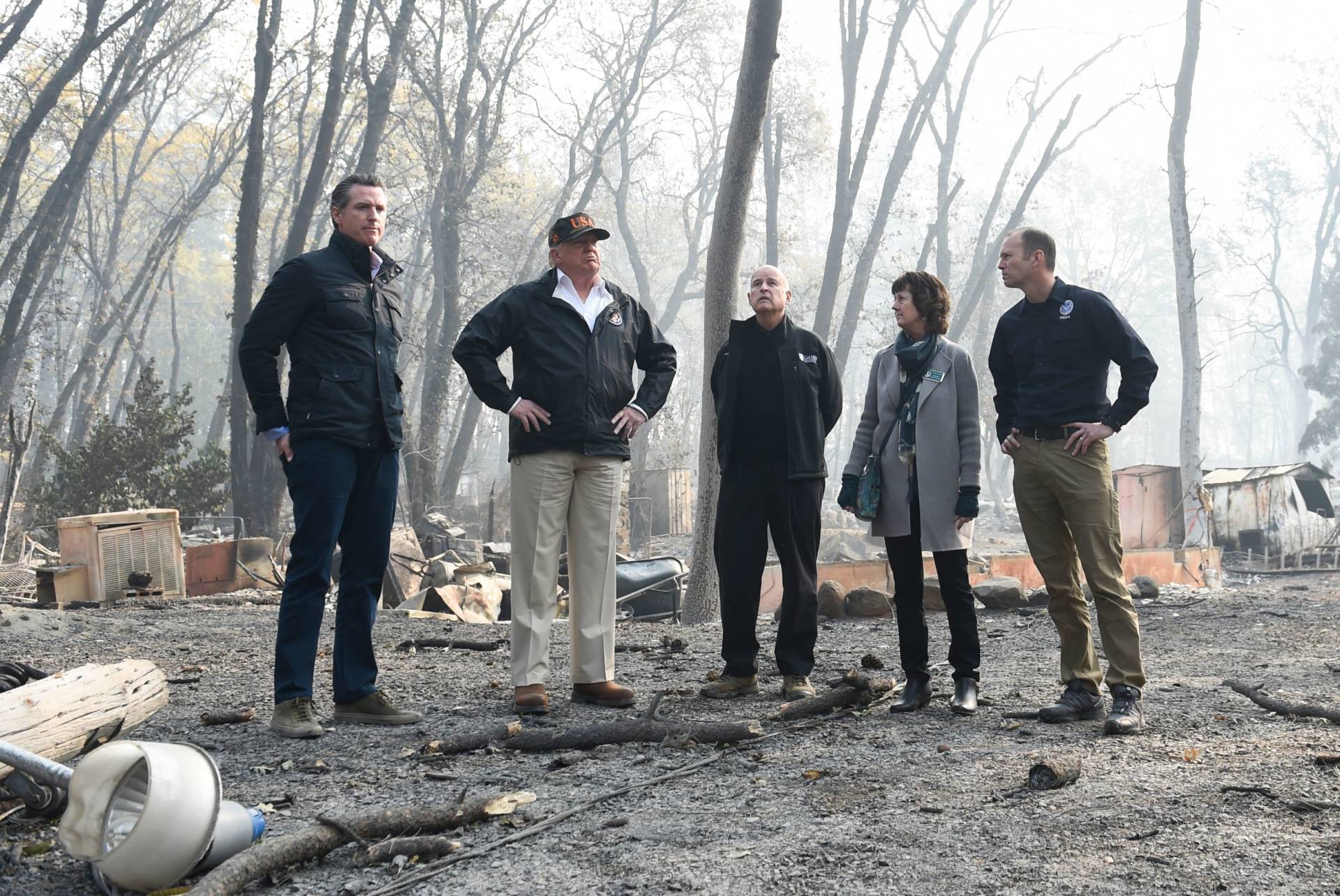 US President Donald Trump (2L) looks on with Paradise Mayor Jody Jones (2R), Governor of California Jerry Brown (C), Administrator of the Federal Emergency Management Agency, Brock Long (R), and Lieutenant Governor of California, Gavin Newson, as they view damage from wildfires in Paradise, California on November 17, 2018. - President Donald Trump arrived in California to meet with officials, victims and the 'unbelievably brave' firefighters there, as more than 1,000 people remain listed as missing in the worst-ever wildfire to hit the US state. SAUL LOEB/AFP/Getty Images