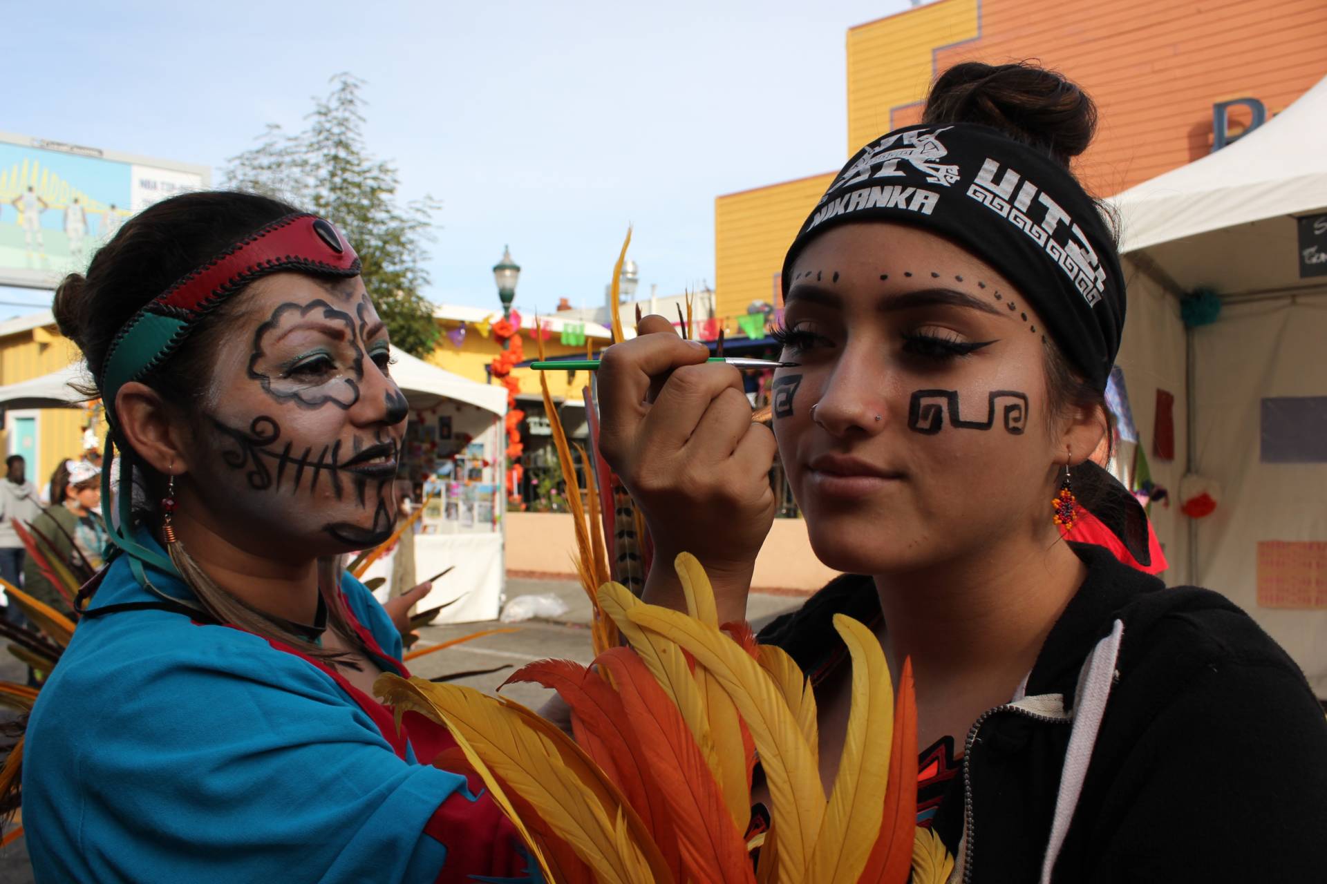 Maricela Sandoval of San Jose paints the face of fellow dancer, Estrella Zamudio, also of San Jose. Sara Hossaini/KQED