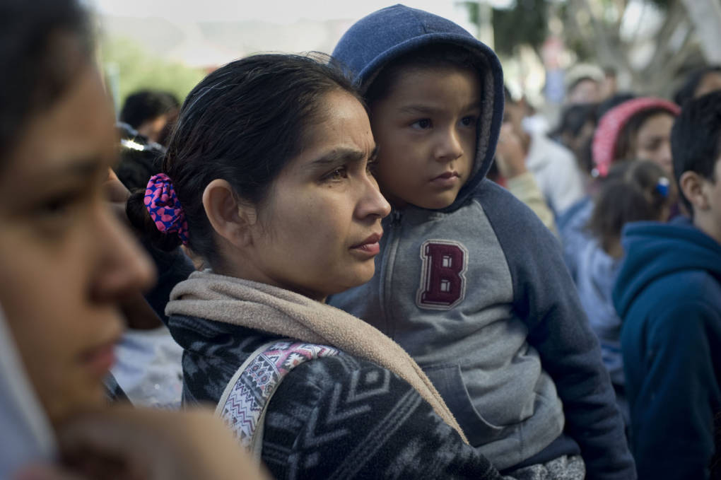 A woman and child in Tijuana, Mexico, wait to hear their position on a list of people hoping to seek asylum in the U.S. on Nov. 21, 2018 David Maung/KQED