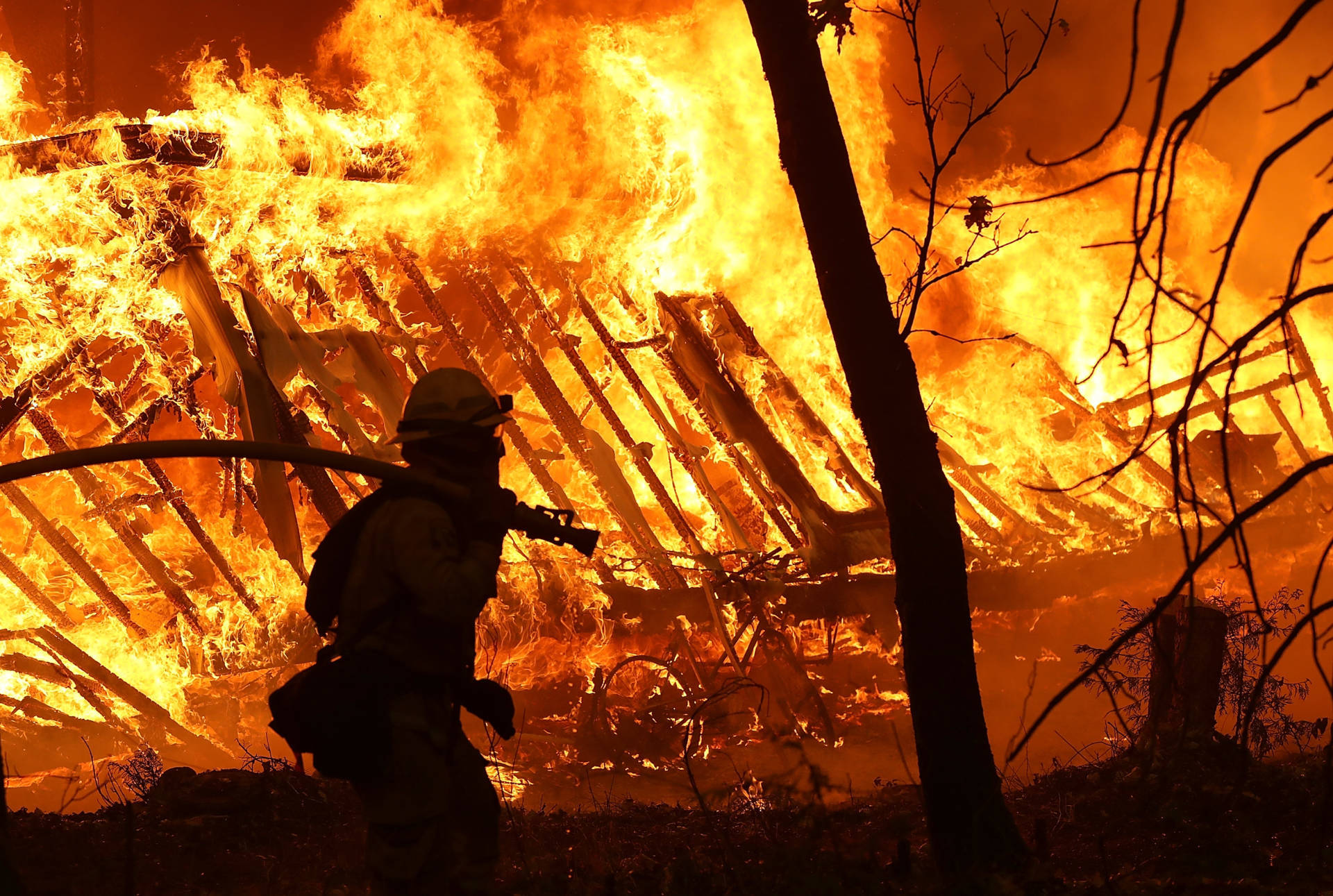 A Cal Fire firefighter monitored a burning home as the Camp Fire moved through Magalia on Nov. 9.  Justin Sullivan/Getty Images