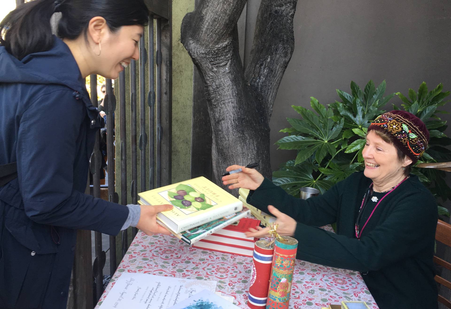 Chef Alice Waters signs books and posters outside of her restaurant. 'Always look for the flea markets, always look for the used. They can be so special because they have so many memories in them,' she says. Caroline Champlin/KQED