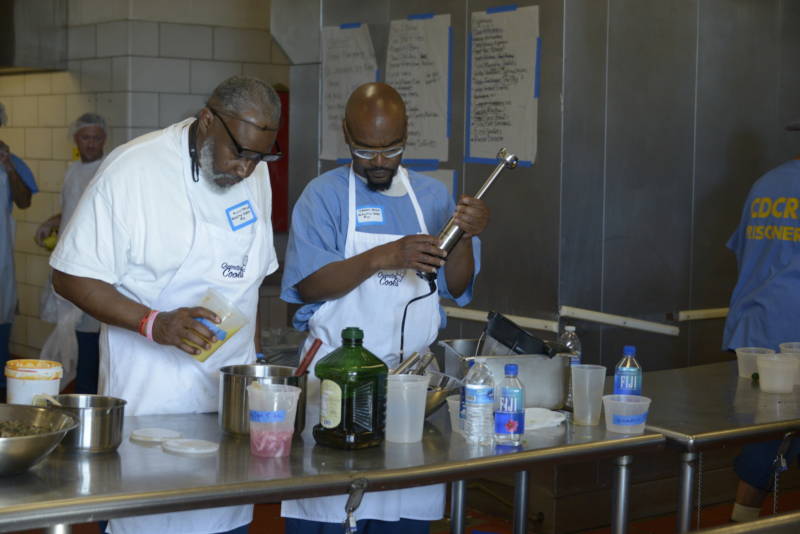 Alvis Taylor (left) and Derry Brown, both incarcerated at San Quentin, prepare food for the fifth Quentin Cooks graduation dinner at San Quentin State Prison on May 22, 2019.